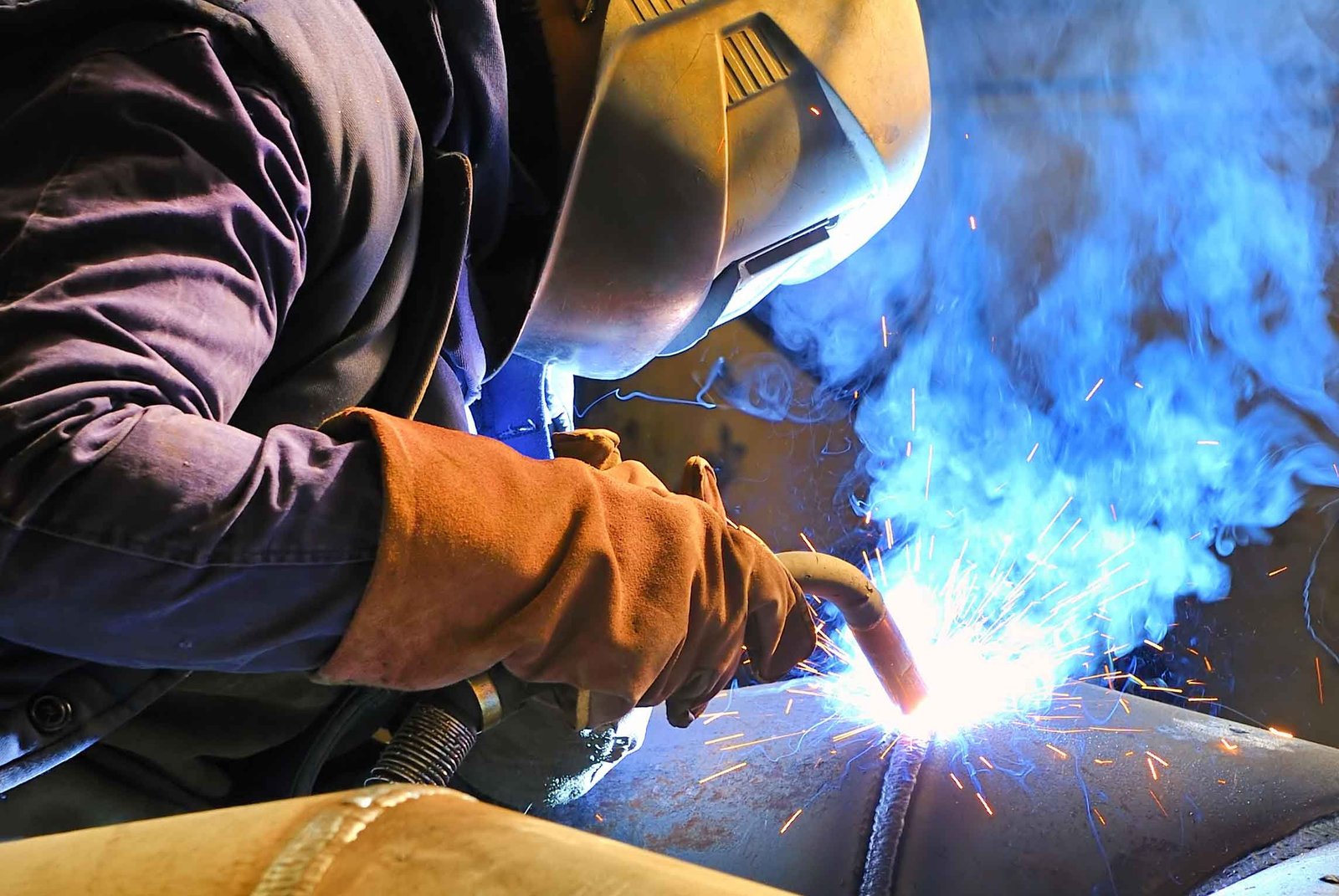 Soldador trabajando en estructura metálica